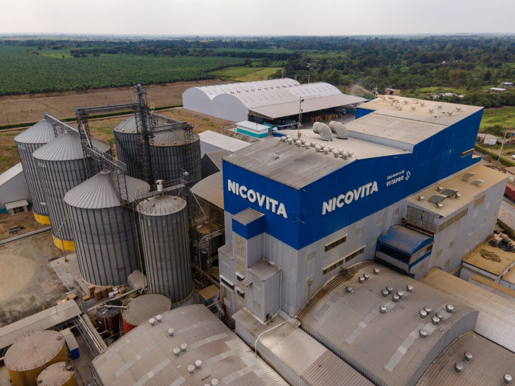 Vista aérea de una planta de alimento balanceado de Nicovita, con silos de almacenamiento y el edificio de producción con la marca Nicovita